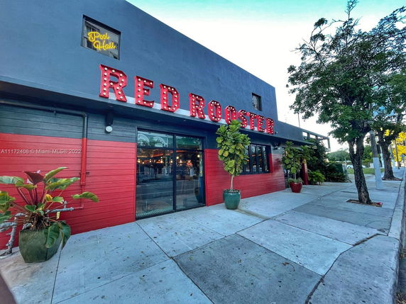 Front view of a commercial building with a red and gray facade and a large sign reading 'Red Rooster'.