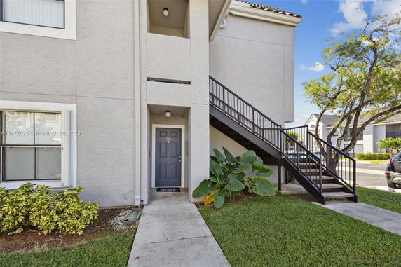 Front view of a multi-story building with an external staircase.