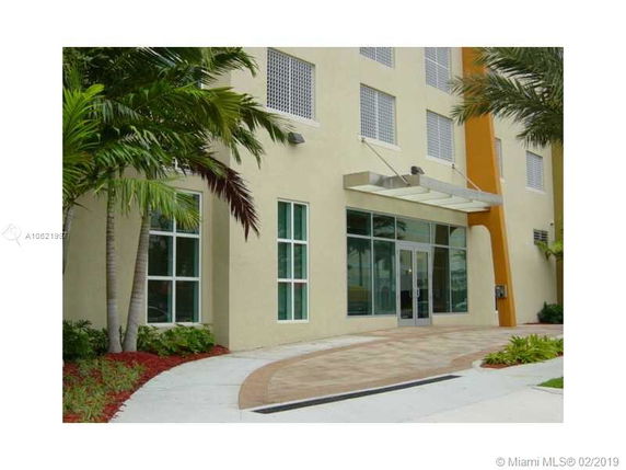 Front view of a modern building entrance with large glass doors and windows.