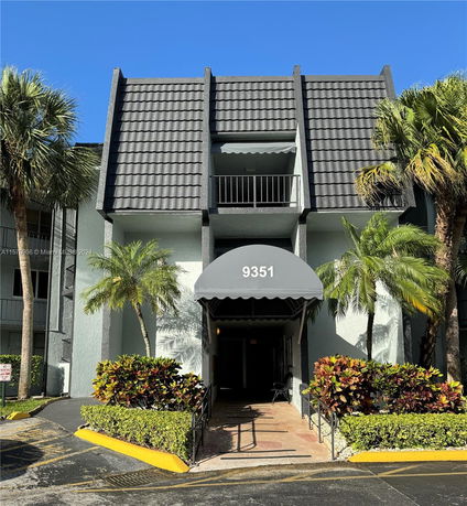 Front view of a multi-story building with a distinctive architectural design and an entrance canopy.