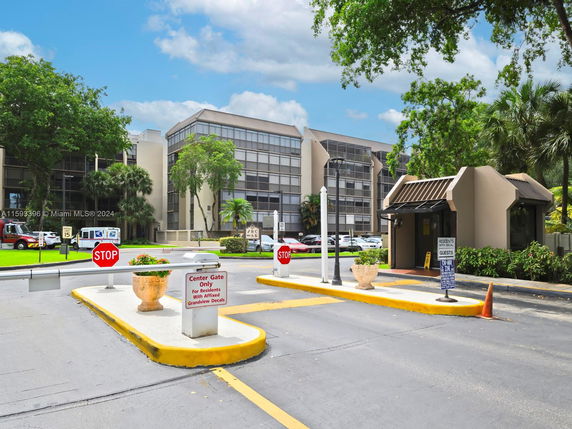 Front view of a multi-story building with large windows and entrance gates.
