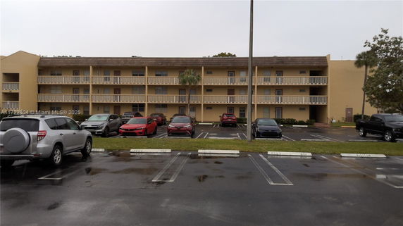 Front view of a three-story apartment building with balconies.