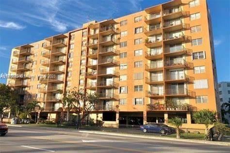 Front view of a multi-story apartment building with balconies.
