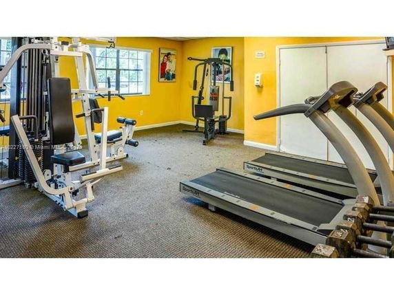 Indoor gym area with fitness equipment including treadmills and weight machines.