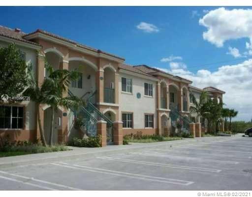 Front view of a two-story apartment building with a parking area.