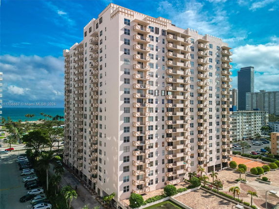 Front view of a tall apartment building with multiple balconies.