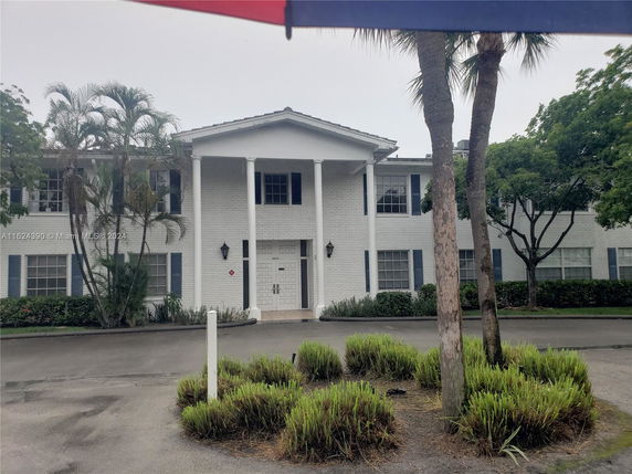 Front view of a two-story building with white brick exterior and columns.