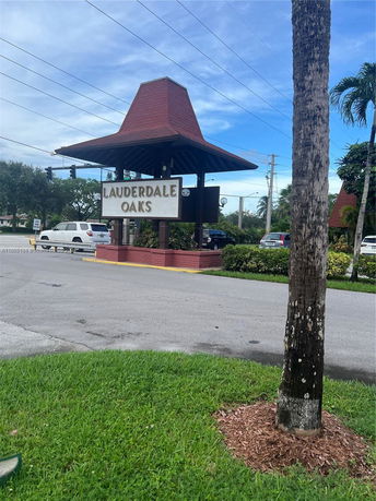 Sign with 'Lauderdale Oaks' at a landscaped entrance.