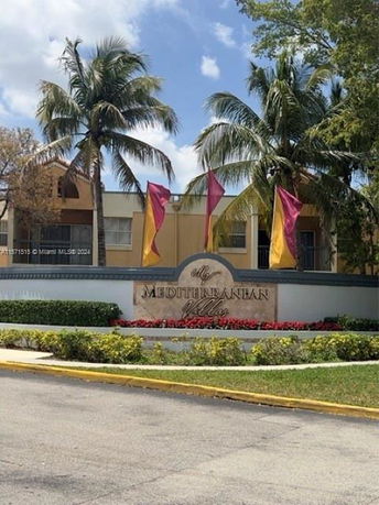 Front view of a building with a Mediterranean Villas sign and colorful flags.