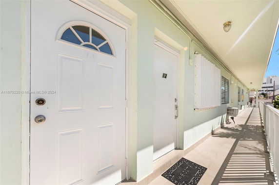 Exterior view of a building corridor with multiple doors.