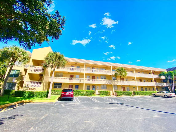 Front view of a three-story apartment building with balconies.