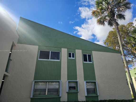 Front view of a two-story building with green and cream exterior.