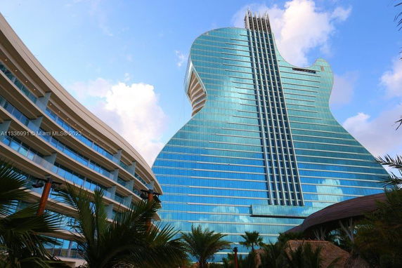 Front view of a glass-covered building shaped like a guitar.