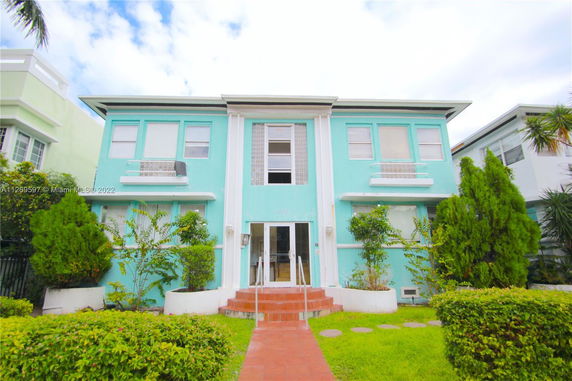 Front view of a two-story house with a central entrance and teal exterior.