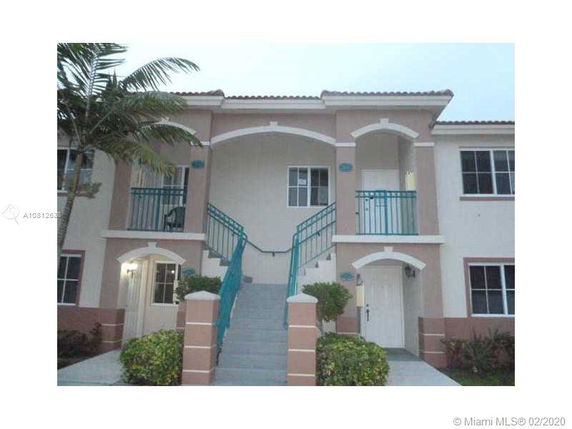 Front view of a two-story building with a central staircase and balconies.