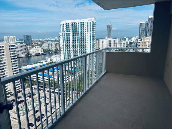 Panoramic view of a cityscape from a high-rise building balcony.
