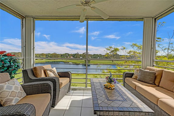 Panoramic view from a patio showing a scenic landscape with a body of water and greenery.