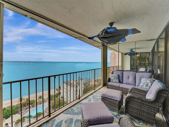Balcony view overlooking the ocean with outdoor seating.