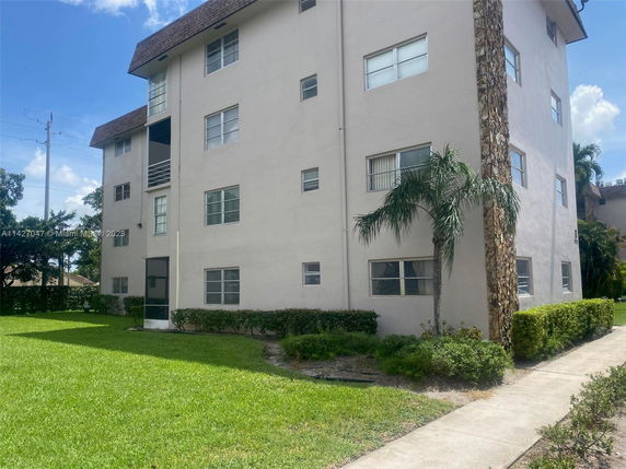 Front view of a multi-story residential building with stone and stucco exterior.