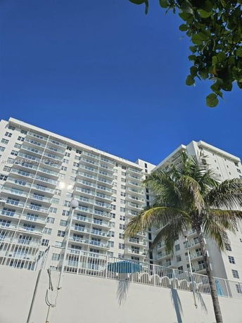 Front view of a multi-story residential building with balconies.