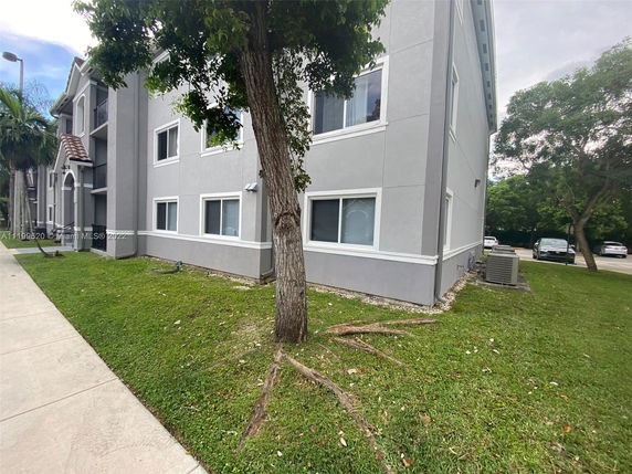 Side view of a two-story building with a grey exterior and white trim.