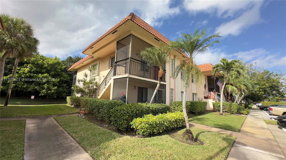 Front view of a two-story building with balconies and a tiled roof.