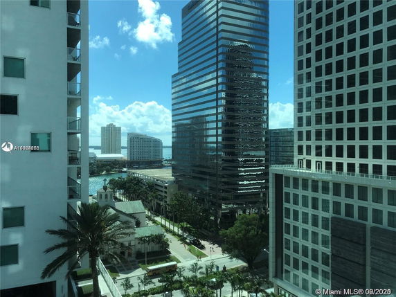 Urban view of multiple high-rise buildings with a water body in the background.