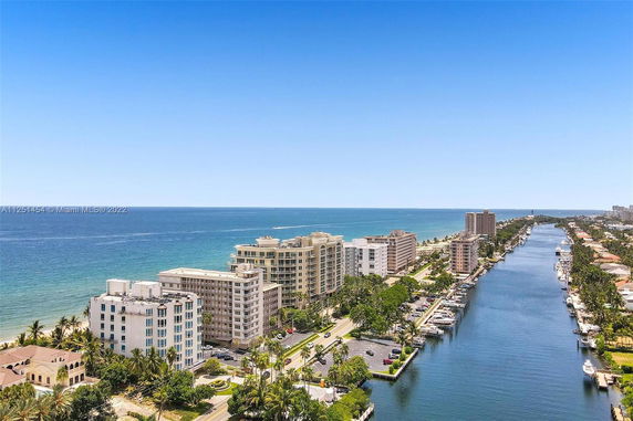 Panoramic view of coastal buildings with ocean and canal.