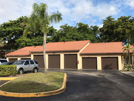 Front view of a building with multiple garage doors and a tiled roof.