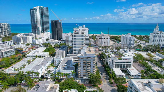 Aerial view of a cityscape with multiple tall buildings near the ocean.