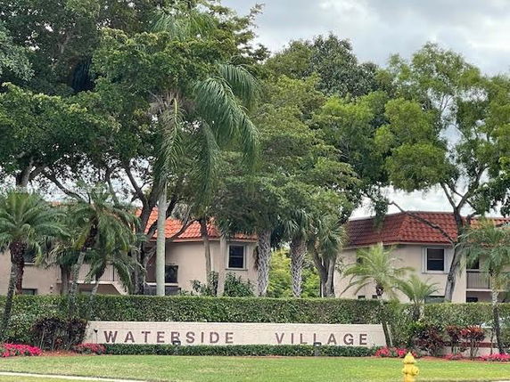 View of Waterside Village with residences and trees in the background.