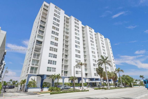 Front view of a multi-story residential building with balconies.