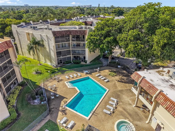 Aerial view of a swimming pool area surrounded by apartments.