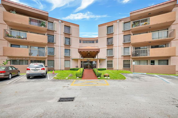 Front view of a multi-story apartment building with balconies.