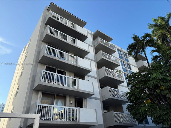 Front view of a multi-story apartment building with balconies.