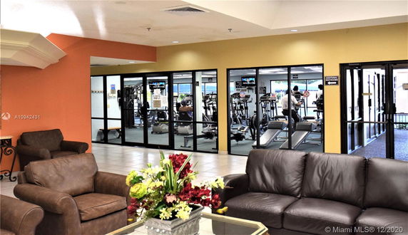 Interior view of a clubhouse gym area with exercise equipment and seating.