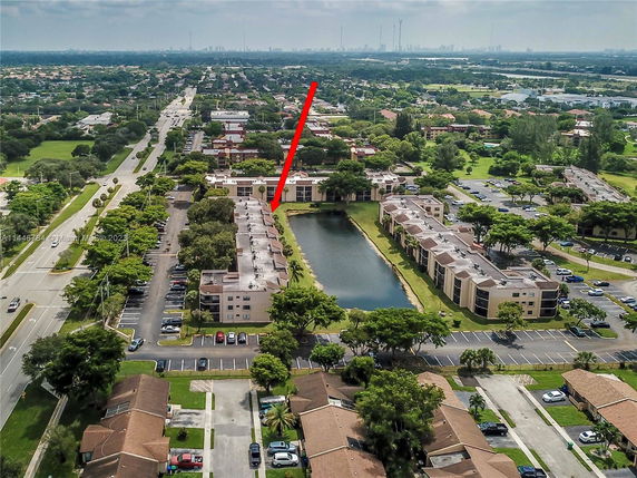 Aerial view of a residential area with multiple apartment buildings and a central water body.
