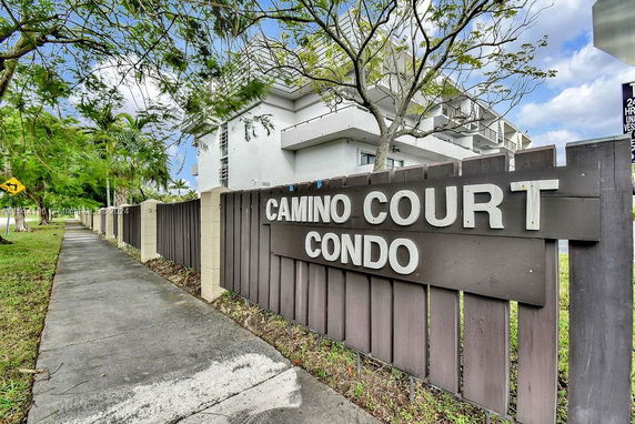 Front view of a condominium building with a sign reading 'Camino Court Condo'.