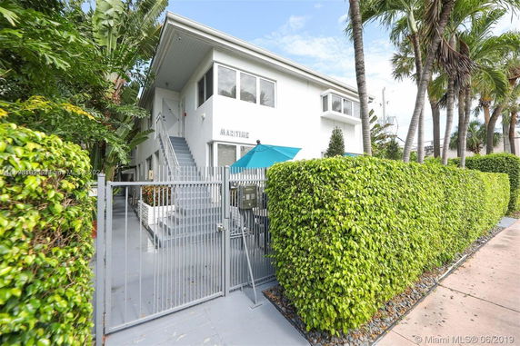 Front view of a two-story building with a gated entrance.
