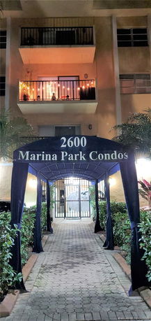 Front view of a condominium building entrance with a canopy labeled '2600 Marina Park Condos'.