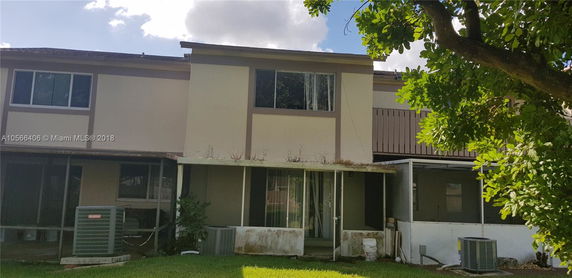 Rear view of a two-story house with a covered patio.
