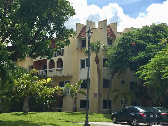 Front view of a multi-story residential building with balconies and distinctive architectural features.