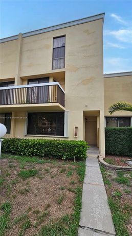Front view of a multi-story house with a balcony.