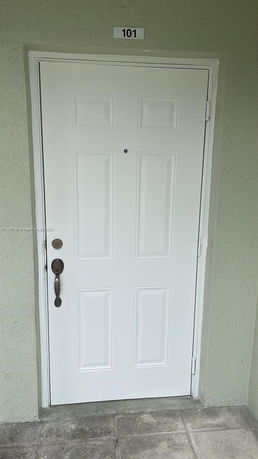 Front view of a white door with the number 101 above it.
