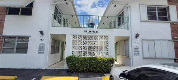 Front view of a multi-story residential building with balconies and decorative grille panels.