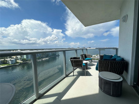 Panoramic view from a balcony overlooking water and distant buildings.