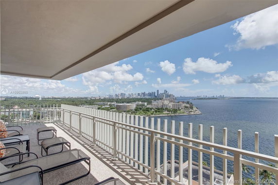 Panoramic view from a balcony overlooking a cityscape and body of water.