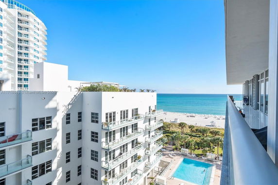 View from a building overlooking a beach and ocean with adjacent structures.