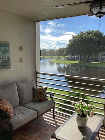 Balcony view overlooking a pond and surrounding landscape.
