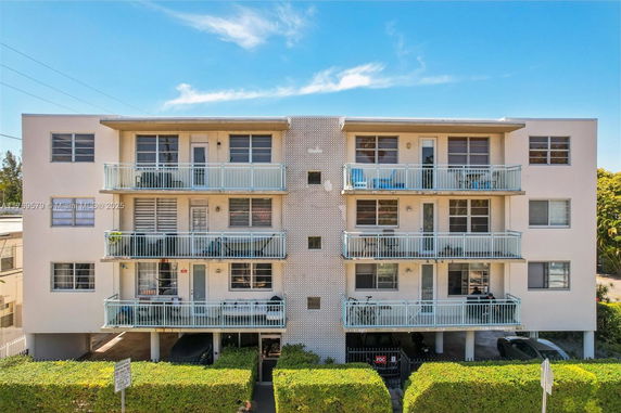 Front view of a three-story apartment building with balconies.